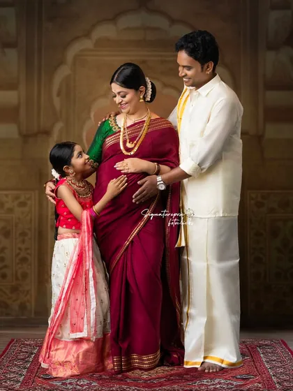 A complete family portrait, beautifully styled in traditional wear, showing the older sibling sharing in the excitement.