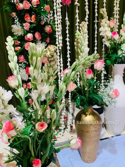 A close-up of the elegant floral arrangements I create. This bouquet features white tuberoses and pink roses, placed in decorative vases to enhance the stage decor.