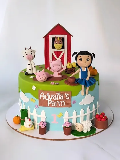 Old MacDonald had a farm! A fun and colorful farm-themed cake for a first birthday, complete with a barn, a little farmer girl, and all her animal friends.