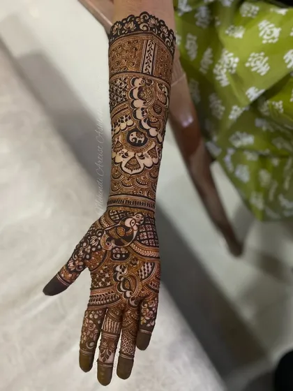 A single-hand view of a detailed bridal design. This showcases the fine line work and the combination of different patterns to create a cohesive piece.