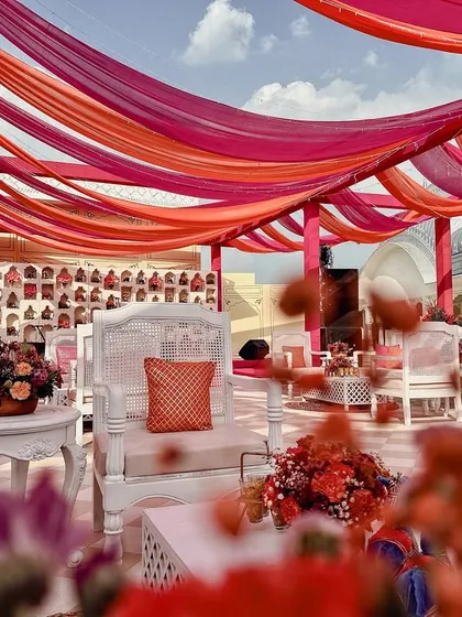 Color is a language I love to speak. This sundowner Mehendi was inspired by Rajasthan's own 'Maharani Pink' and vibrant orange, using flowing drapes and crisp white furniture to create a joyful and energetic celebration on a palace rooftop.