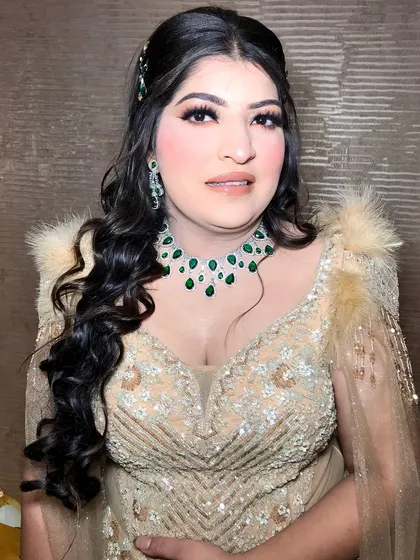 A close-up of the bride, showing her emerald and diamond necklace and matching earrings.