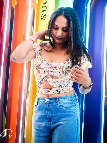 A stylish guest posing against the colorful, illuminated surfboards at Sugar Factory. The venue's unique decor provides a great backdrop for photos.