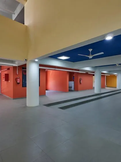 The interior parking and entrance area of the Ankleshwar skill development center, where the interior color scheme of red, yellow, and blue reflects the building's exterior architectural theme.