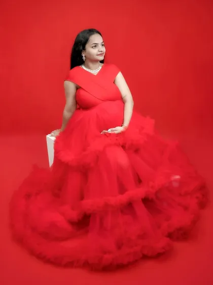 A simple, solid red background makes the texture of this ruffled gown pop. This is a great example of how we can create a high impact look with just color and light.