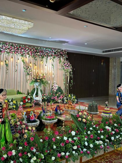 A side view of the stage with the green sofa, showing the offering table and traditional dolls.