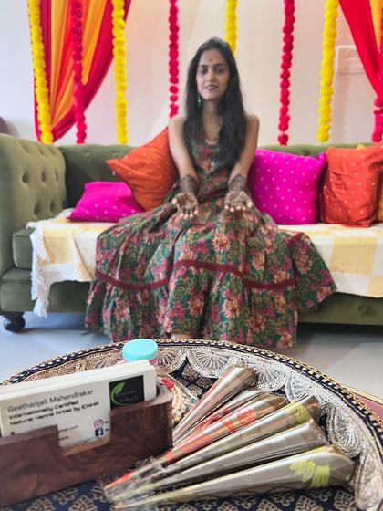 The bride-to-be posing with my setup of organic henna cones, ready for her intricate mehendi session.