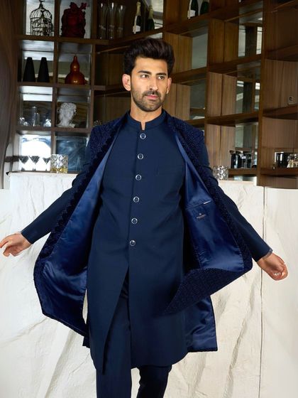 The navy Indo-Western jacket is opened to reveal the rich satin lining and the sleek kurta underneath. This shows the quality of construction, inside and out.