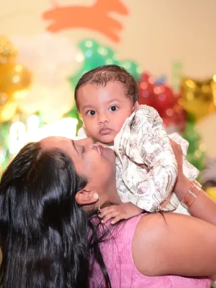 A mother holding her baby at a party. Our space is safe and welcoming for even the youngest guests.