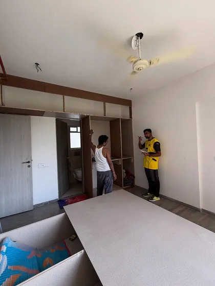 Supervising the wardrobe installation in a bedroom. The loft storage is also being constructed.
