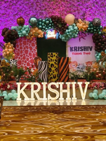 The complete jungle stage setup for Krishiv's second birthday. The decor includes a custom backdrop, animal cutouts, and a multi-colored balloon arch.