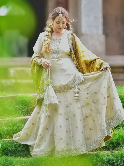 Capturing the full flow and elegance of the designer lehenga as she walks down the steps. This is a perfect shot to showcase the movement and grace of the outfit.