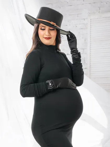 For the modern mom-to-be, I offer chic and stylish maternity portraits. This look, featuring a sleek black dress and a fashionable hat, creates a powerful and confident statement.