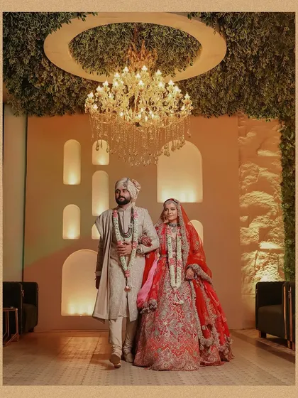 The couple makes their grand entrance as husband and wife. This shot captures their confident walk and the beautiful decor of the wedding venue.