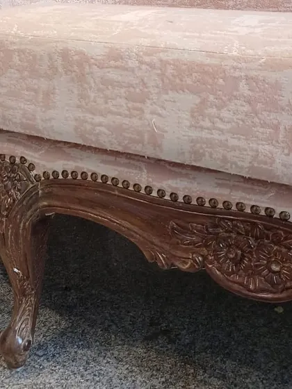 Another detail shot of the classic carved sofa, focusing on the nailhead trim and the sculpted legs. These elements add a layer of refinement and are a hallmark of traditional furniture making.