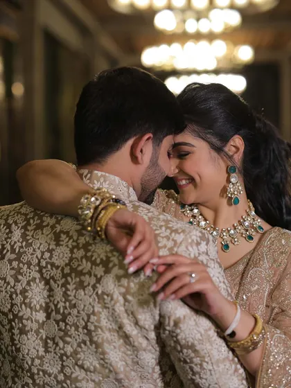 A sweet moment from our engagement. The intricate white embroidery on his jacket beautifully complements the delicate pearl work on my golden lehenga, showing how details can tie two looks together.