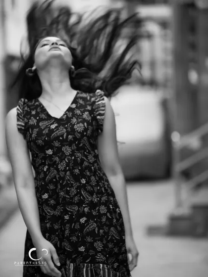 An expressive shot, capturing the pure energy of a hair flip in stunning black and white. It's a portrait of liberation and uninhibited joy.