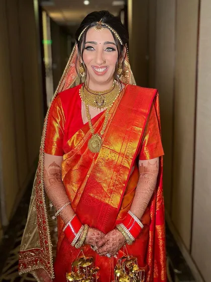 A beautiful South Indian bride in a traditional red silk saree. We kept the makeup classic and elegant to complement her golden temple jewelry.
