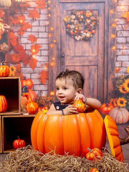 Giggling inside a pumpkin. This photo captures the pure joy and fun of our seasonal pumpkin patch theme.
