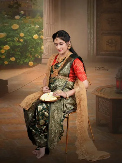 A moment of quiet contemplation, with the mother-to-be seated in a traditionally draped saree. The antique props and warm lighting evoke a sense of timelessness and heritage.