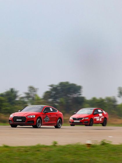 A head-to-head battle between two performance sedans, a red Audi and a red Skoda, showcasing the fierce competition in our various car classes.