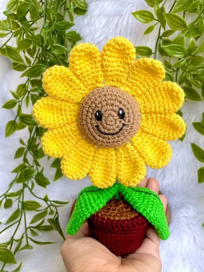 Another angle of the happy potted sunflower, showing its bright yellow petals and green leaves.