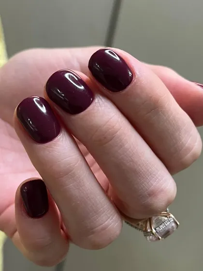 A rich, deep burgundy polish on rounded nails. This classic autumn and winter shade is sophisticated and timeless.