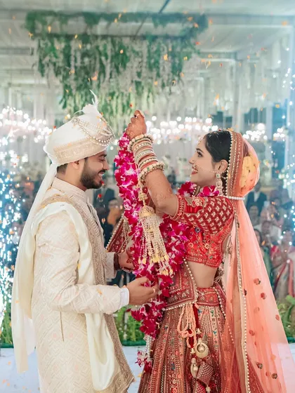 The Varmala exchange is a moment of pure celebration. I captured Nikita and Akash during this peak moment, with cold pyrotechnics adding a touch of modern spectacle to the traditional ritual.