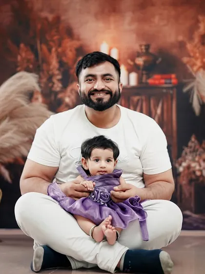 A proud father sits with his daughter for her half-birthday portrait, a beautiful memory of this special time.