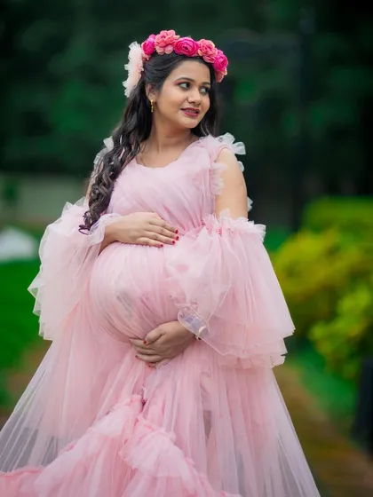 A close-up portrait showcasing the intricate details of this pink ruffled gown and the radiant glow of the mom-to-be. Professional makeup is included to make you feel your best.