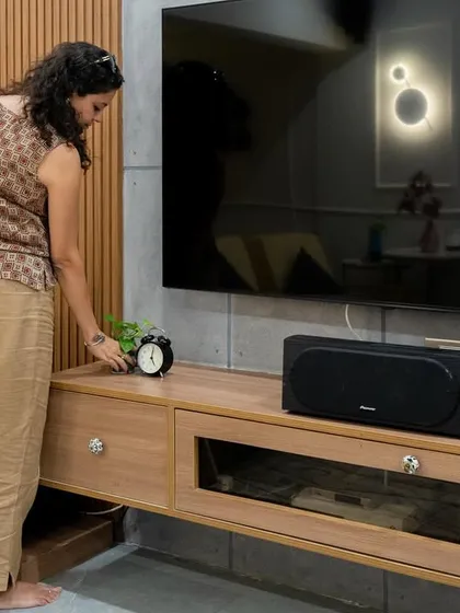 A candid shot of me styling the TV unit in the modern living room, adding the final touches.