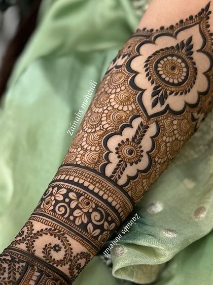 A close-up of the upper portion of Maheen's bridal henna, featuring a large mandala and intricate band work.