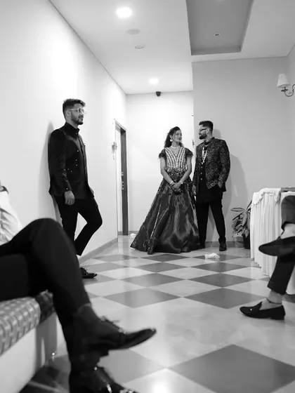 A creative, moody shot in black and white, showing the couple in the background while their friends relax in the foreground.