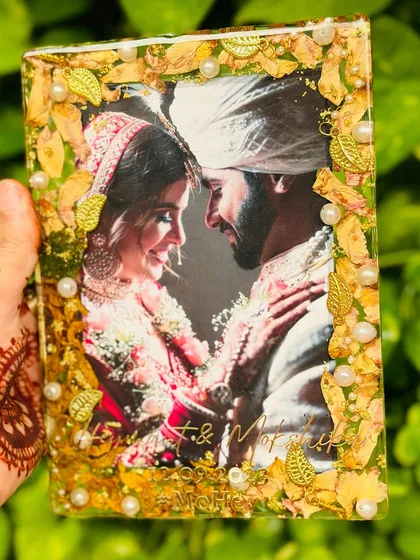 A beautiful moment from a wedding, captured forever. I preserved this couple's varmala flowers around their photo in a rectangular resin frame, complete with their names and wedding date engraved in gold.