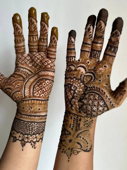A beautiful example of asymmetrical designs for the hands. One hand features a delicate floral pattern while the other has a more geometric, filled-in style.