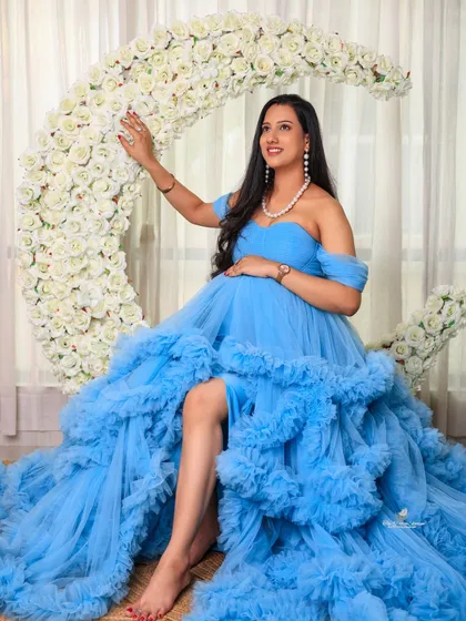 The mom-to-be looks like a goddess on our floral moon prop. This solo shot highlights the grandeur of the ruffled gown and the magical theme of the setup.