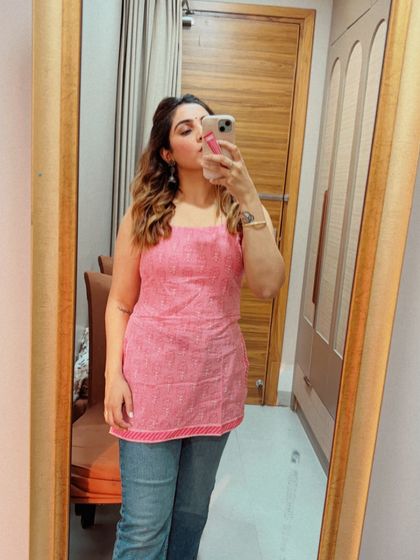 A close-up of the pink short kurti and jeans look. The simple, clean lines of the kurti make it a versatile piece that can be dressed up or down, perfect for a casual day out.