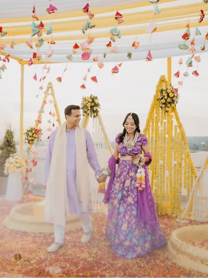 The couple walking hand in hand through their beautifully decorated haldi venue. The soft, dreamy edit enhances the romantic and celebratory mood of the moment.
