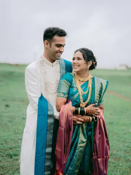 The vibrant colors of a traditional Paithani saree against a lush green field. This portrait from a pre-wedding shoot near Pune showcases the elegance of Maharashtrian attire in a natural, open setting.