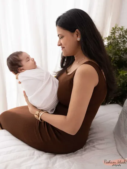 A quiet moment of admiration. This side profile shot beautifully captures a new mother gazing at her baby.