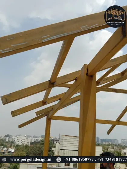 A close-up of the apex of the pergola frame, showing the joinery and construction details.