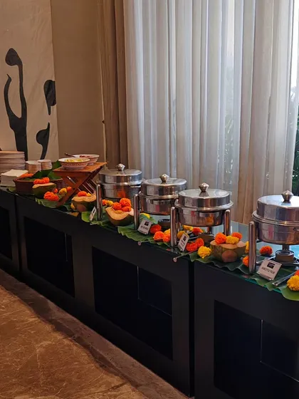 When I cater your house party, I bring the whole vibe. This buffet setup shows how I blend professional service with a warm, festive touch using banana leaves and marigolds, making your event feel special and personal.