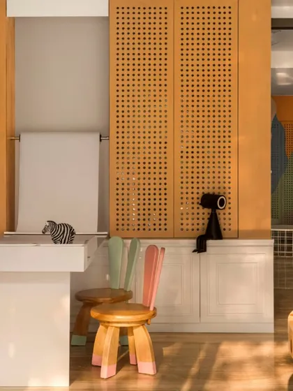 I designed these custom bunny-eared stools to bring a sense of fun and whimsy to the space. Paired with perforated wood panels and a paper roll for drawing, this corner is all about encouraging creativity.