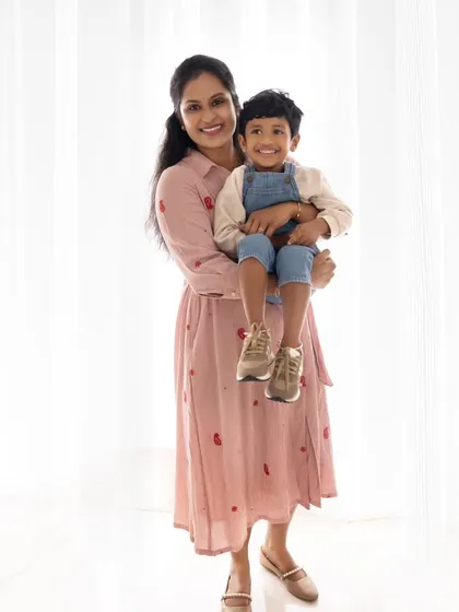 A classic mother and son portrait. The mother holds her son, and both share a happy smile for the camera, capturing a perfect memory.