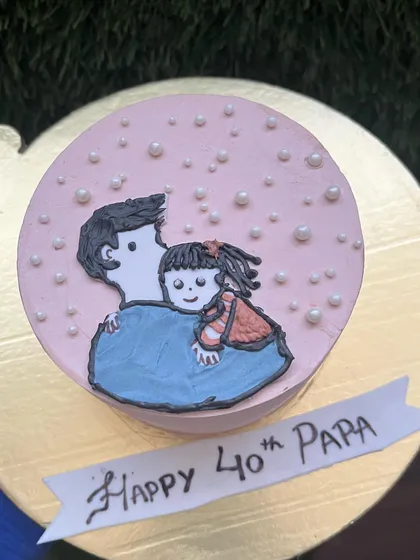 An overhead view of the heartwarming father-daughter doodle cake, decorated with edible pearls for a touch of sparkle.