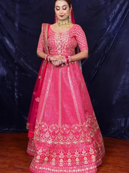 This bright pink lehenga with checked patterns and a golden border is a vibrant and joyful choice for any wedding function.