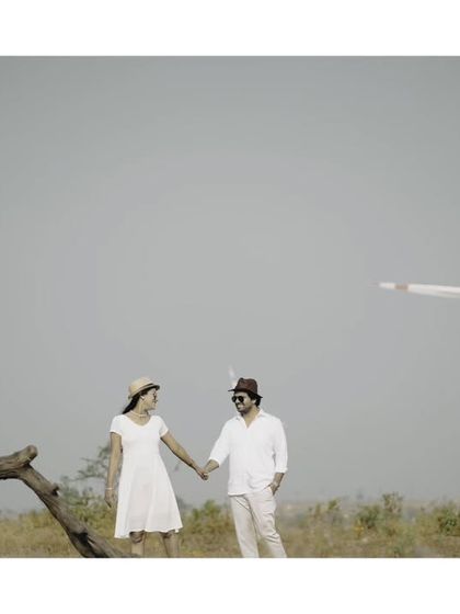 A stylish pre-wedding portrait with a vintage feel, using the unique landscape of a windmill farm.