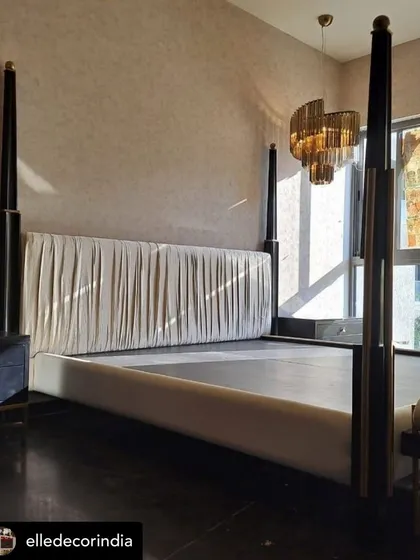 A majestic four-poster bed with a beautifully draped fabric headboard, featured in Elle Decor. This piece combines classic grandeur with modern luxury.