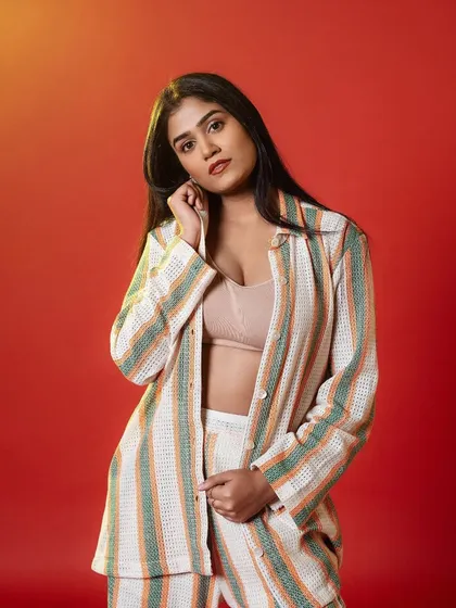 A chic and modern look for this photoshoot. The makeup is clean and fresh, with a focus on a flawless base and a soft, neutral lip, perfectly complementing the striped co-ord set.