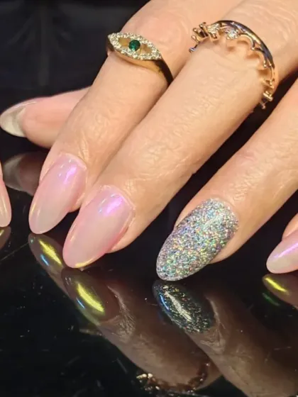 A stunning combination of pearlescent pink nails and a full-coverage holographic silver glitter accent nail.